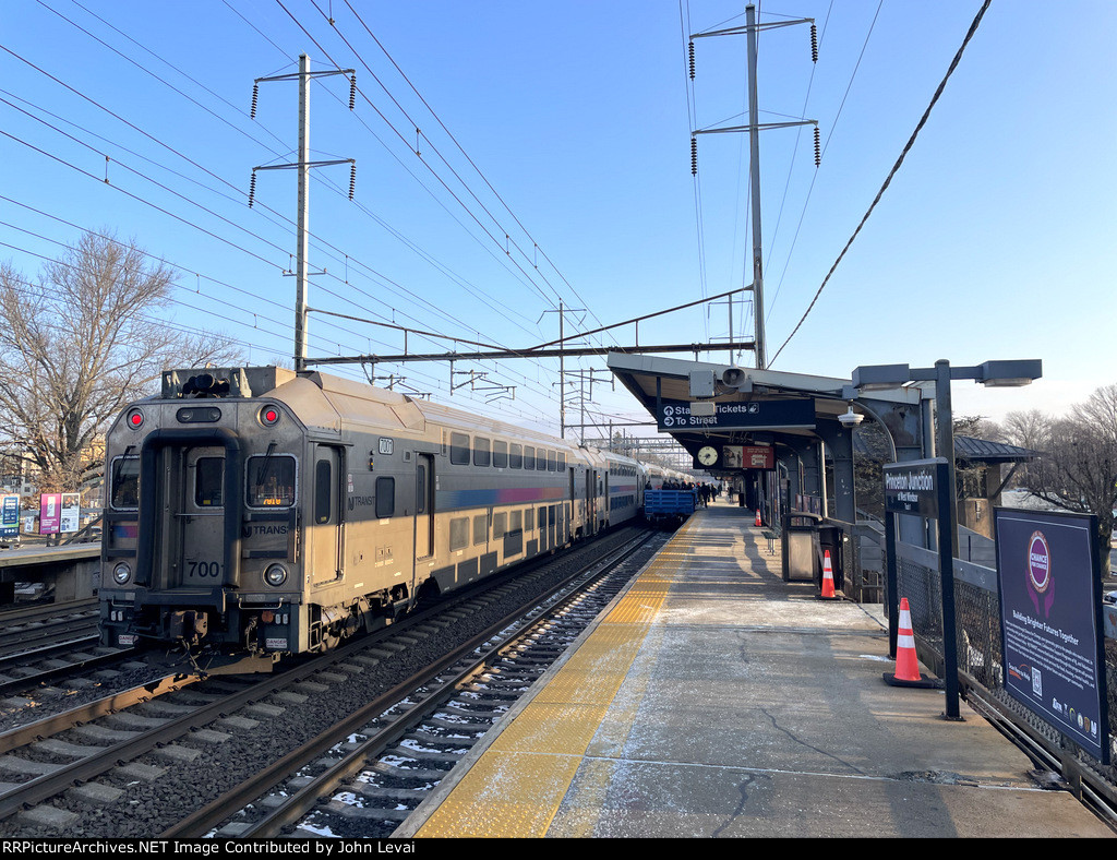 NJT Multilevel Cab Car # 7001 on the rear of NJT Train # 7818-note the passengers walking from the platform across the gondolas to board the eastbound train 